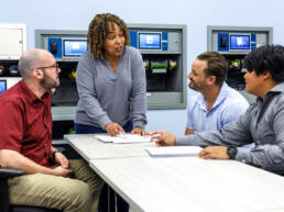 Female instructor talking to trainees at a table